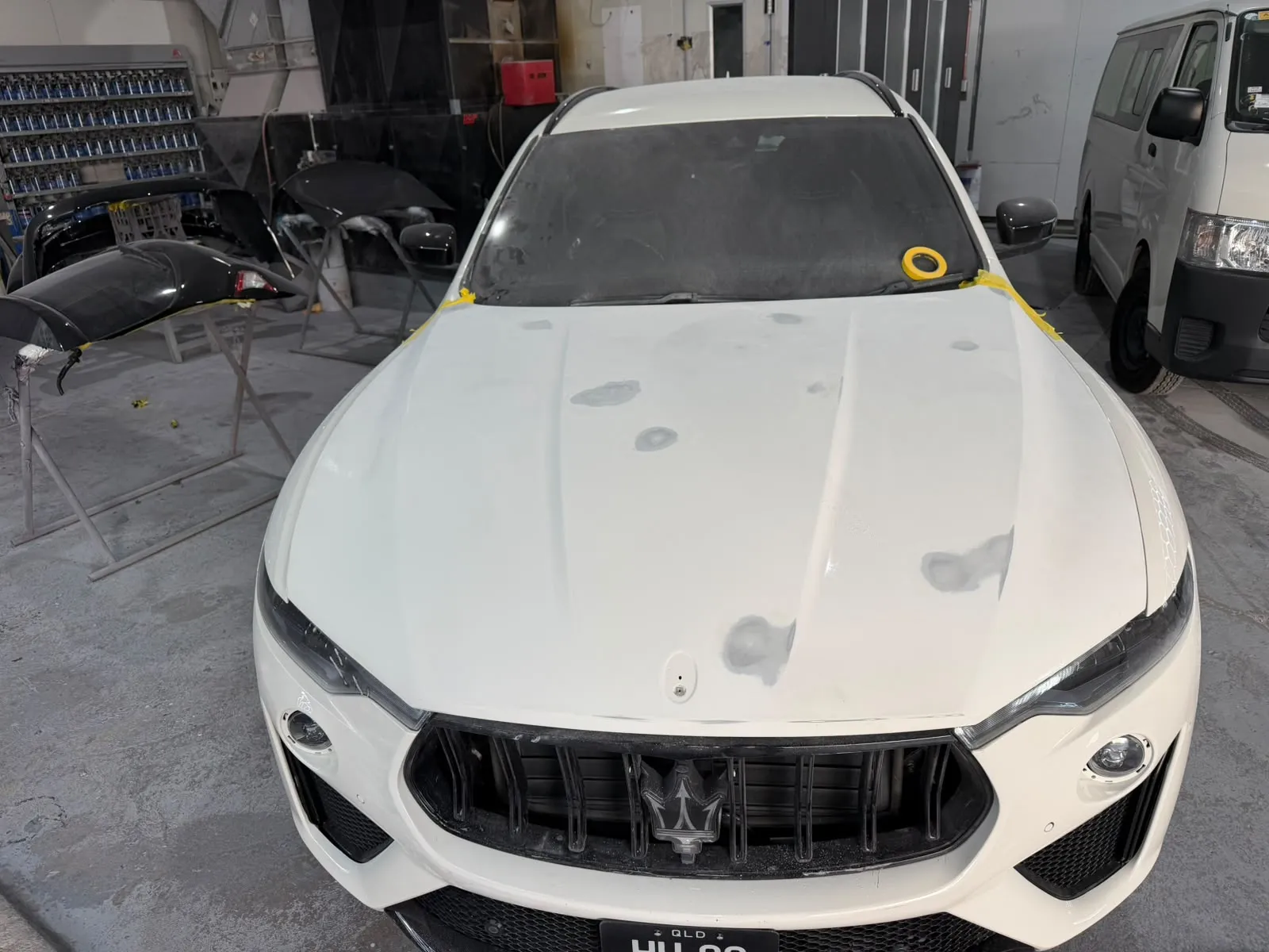 White Maserati Levante with its bonnet primed and prepped before a respray
