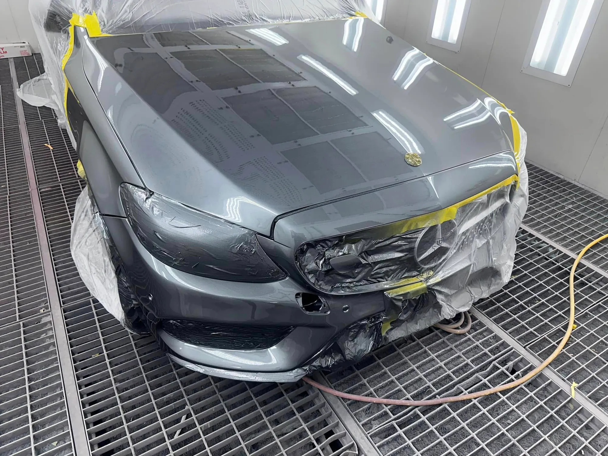 Mercedes-Benz coupe masked for a respray in the spray booth