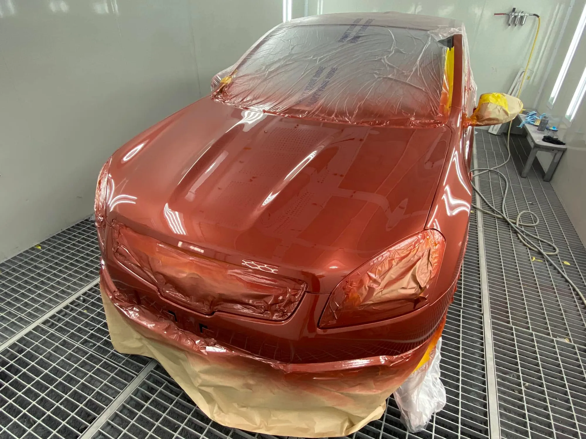 Sedan front masked and resprayed in red metallic