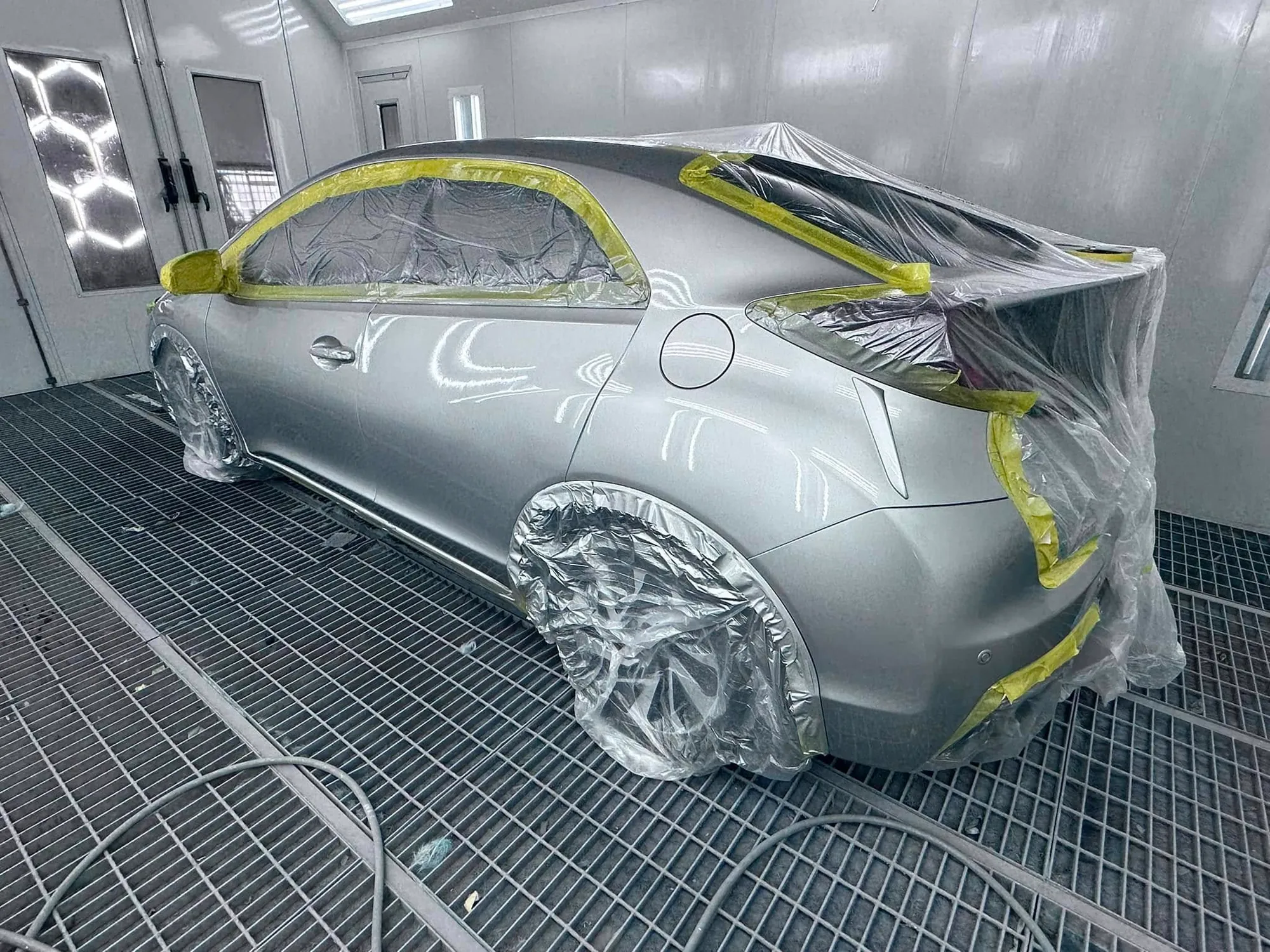 Silver hatchback masked up for a full respray