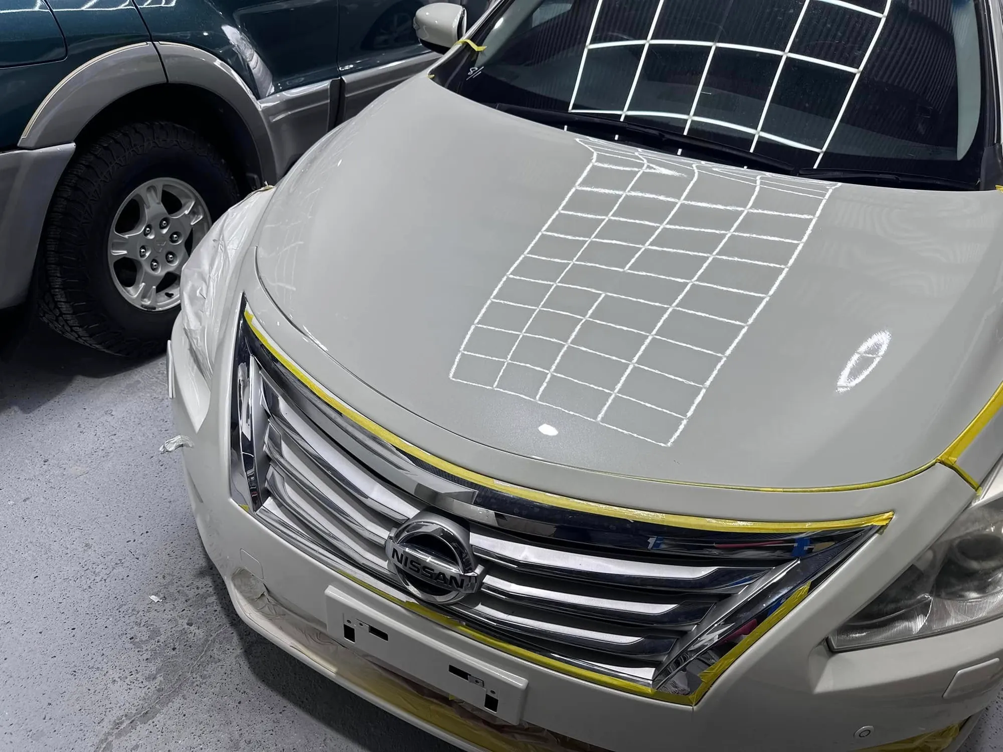 Silver Nissan bonnet masked and prepped for painting