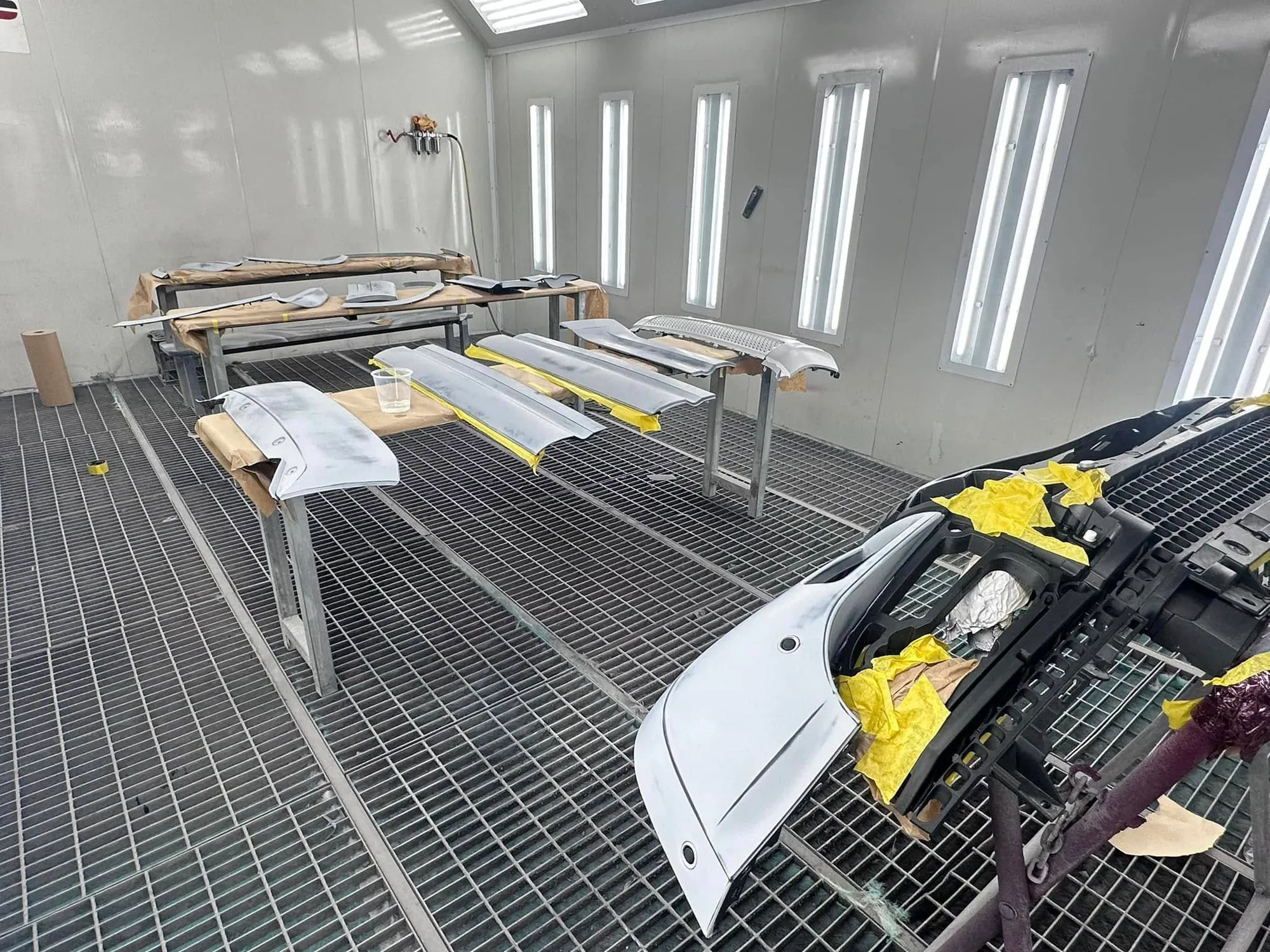 White body panels drying in the spray booth after painting